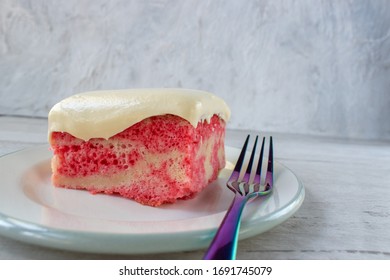 Slice Of Yellow Jello Cake With Pudding Frosting On Plate With Fork