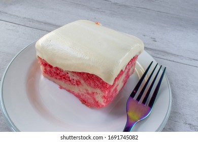 Slice Of Yellow Jello Cake With Pudding Frosting On Plate With Fork