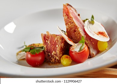 Sliced Ahi Tuna Steak With Honey Mustard Sauce And Cherry Tomato. Slightly Roasted Red Fish Carpaccio Or Tataki With Herbs And Spicy Sauce Close Up