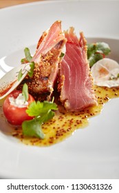 Sliced Ahi Tuna Steak With Honey Mustard Sauce And Cherry Tomato. Slightly Roasted Red Fish Carpaccio Or Tataki With Herbs And Spicy Sauce Close Up