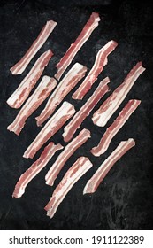 Sliced Bacon On Black Background, Overhead View. Streaky Fresh Bacon Top View.