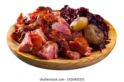 Sliced Baked Pork Shank Served With Vegetable Garnish Of Braised Red Cabbage On Wooden Board. Isolated Over White Background
