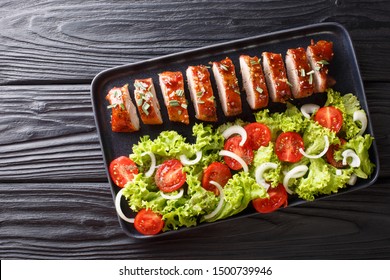 Sliced Baked Pork Tenderloin In Honey-garlic Sauce With A Side Dish Of Vegetable Salad Close-up On A Plate On The Table. Horizontal Top View From Above
