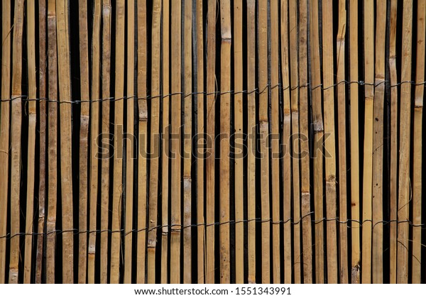 Sliced\
bamboo slats woven together by wire.  Fence privacy screen.\
Ornamental fence divider. Reed garden\
decoration