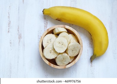 a sliced banana in a bowl on wooden background - Powered by Shutterstock