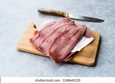 Sliced Beef Tongue Slices on Wooden Board.