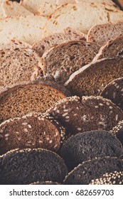 Sliced black bread gradient background. Bakery and grocery concept. Fresh, healthy whole grain sliced sorts of rye and white loaves on wood