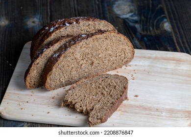 Sliced black rye bread on a board, plain fresh bread cut into pieces on a board - Shutterstock ID 2208876847