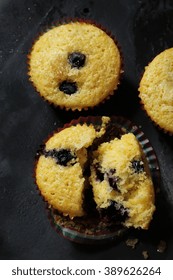 Sliced Blueberry Corn Muffins On Dark Grey Background Overhead View