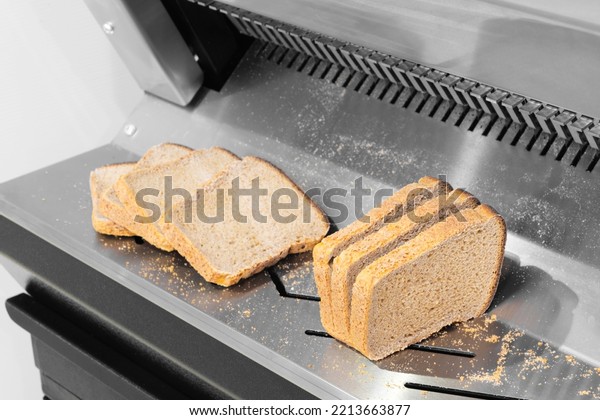 Sliced  bread in cutting\
machine,  Industrial bread Slicer in supermarket with bread crumbs,\
ready to use.