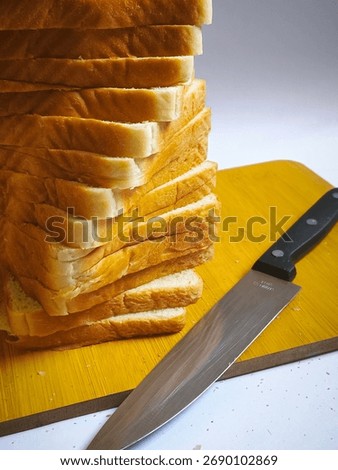 Sliced Bread and Knife 🍞🔪
A tall stack of golden-brown sliced bread placed on a wooden cutting board beside a sharp kitchen knife. The bread looks soft and fluffy, ideal for making sandwiches or toa