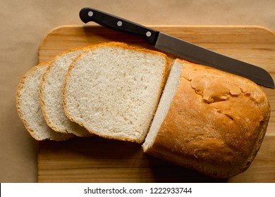 Sliced Bread Loaf And Knife On Cutting Board. Top Down View.