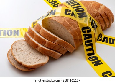 Sliced Bread And Yellow Caution Tape Isolated On White Background Concept For Food Insecurity, Hunger Warning And Hazardous Processed Grain