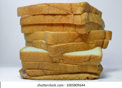 Sliced Bread.Multiple Sheets Vertical Alignment.On A White Background. It Is Made From Wheat Flour Mixed With Water And Yeast Or Baking Powder. Can Be Used As A Background Image For Food And Cakes.