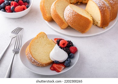 Sliced bundt pound cake dusted with powdered sugar with fresh berries and whipped cream - Powered by Shutterstock