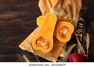 Sliced Butternut Pumpkin, Red Apple, Wheat Grass On Wooden Table