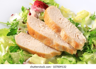 Sliced Chicken Breast Fillet On A Nest Of Green Salad 
