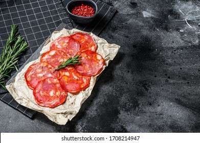 Sliced chorizo salami. Spanish traditional chorizo sausage. Black background. Top view. Space for text