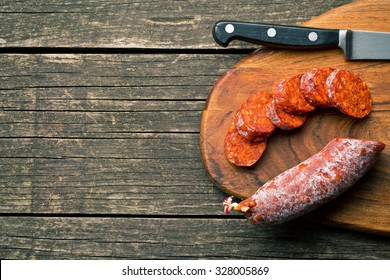 Sliced Chorizo Sausage On Old Wooden Table