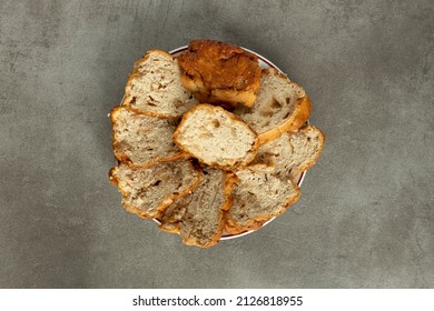 Sliced Colorful Orange Brown Sugarloaf Bread On A Wooden Cutting Board Contrasted Against A Clean Minimalist Contemporary Fashionable Rustic Gray Kitchen. Top Down Studio Food Still Life