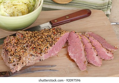 Sliced corned beef with cabbage in abowl on a cutting board