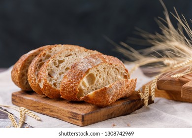 Sliced craft bread on a board close-up on a dark background. The concept of healthy food and traditional bakery. Rustic. - Shutterstock ID 1308742969