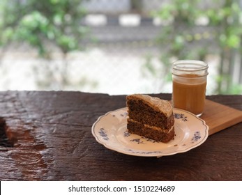 A Sliced Of Earl Grey Cake Served On A Small Plate. A Glass Of Latte. High Angle View.