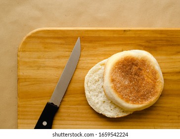 Sliced English muffin and kitchen knife on cutting board - Powered by Shutterstock