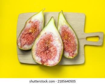 sliced figs on a cutting board. Juicy ripe fruit on a yellow background. Diet food. Fig isolate. Seeds inside. Bright picture. fruit concept