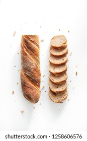 Sliced French Bread Isolated On A White Background. Baguette Slices And Crumbs Viewed From Above. Top View