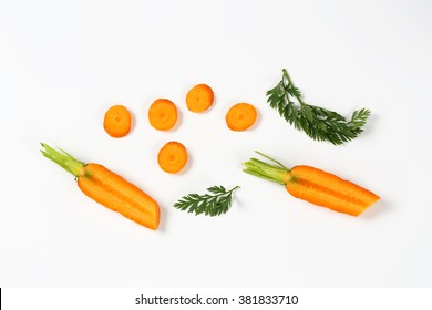 Sliced Fresh Carrots With Leaves On White Background