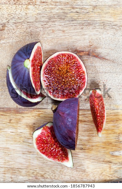 sliced fruit of ripe figs
on a wooden kitchen board, close-up of figs for cooking, red
delicious fig pulp