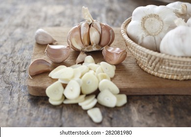 sliced garlic, garlic clove, garlic  bulb in wicker basket place on chopping block on vintage wooden background - Shutterstock ID 282081980