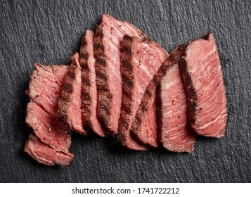 Sliced grilled beef fillet steak on black background top view - Shutterstock ID 1741722212