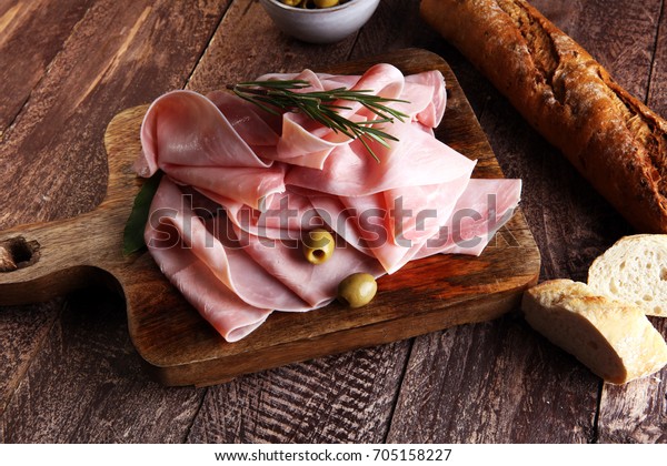 Sliced ham on wooden background. Fresh\
prosciutto. Pork ham\
sliced.
