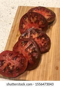 Sliced Heirloom Tomato With Sea Salt On A Cutting Boat