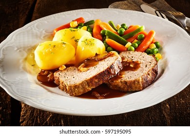 Sliced Homemade Roasted Meat Loaf With An Assortment Of Fresh Healthy Vegetables And Gravy In A Close Up View On A White Plate