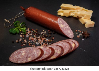 Sliced Jalapeno Cheddar Summer Sausage With Sliced Pieces Served With Pink Salt, Spices, Hard Cheese And Green Basil