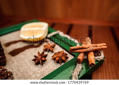 Sliced lemon slice in the background with cinnamon sticks in the foreground