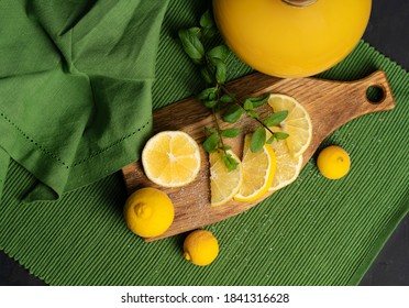 sliced lemons with sugar on a wooden cutting board, on a green napkin with a bottle of juice, top view - Powered by Shutterstock