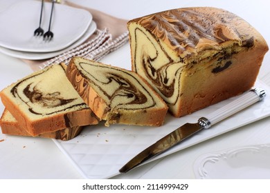 Sliced Loaf marble Cake on White Plate, Wooden Table. Homemade Baked Goods  - Powered by Shutterstock