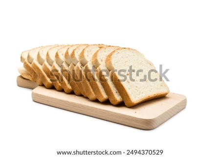 Sliced loaf of white bread on cutting board, isolated on white background.