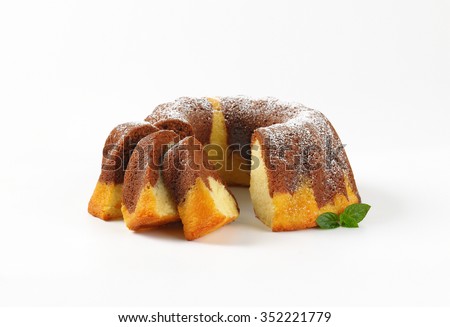 sliced marble bundt cake on white background
