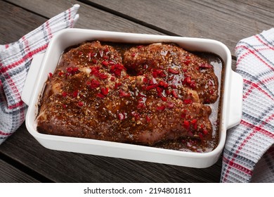 Sliced meat filled with marinade with paprika, spices and herbs, ready for cooking.