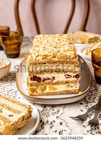 Sliced Moskva cake on a rustic table, famous Moskva hotel from Belgrade signature dessert with buttery cream layers filled with cherries and pineapple pieces tossed with almond flakes