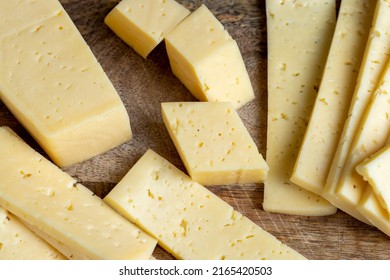 sliced natural cow's milk cheese, fresh yellow milk cheese on a board