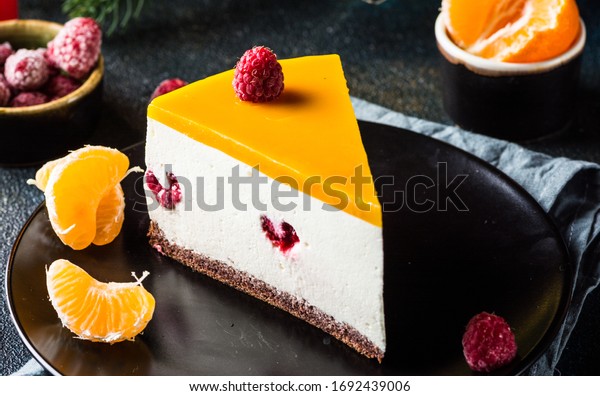 Sliced No Bake\
mango Cheesecake Decorated with Fresh raspberry and tangerine.\
Healthy dessert. Vegetarian food. Raw food. Raw dessert. Piece of\
cake. Mothers day. Summer\
cake