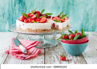 Sliced No Bake Strawberry Cheesecake Decorated with Fresh Berries and Mint - Powered by Shutterstock