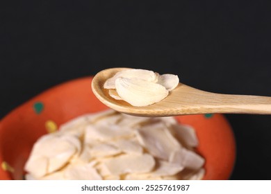 Sliced ​​garlic on a wooden spoon  - Powered by Shutterstock