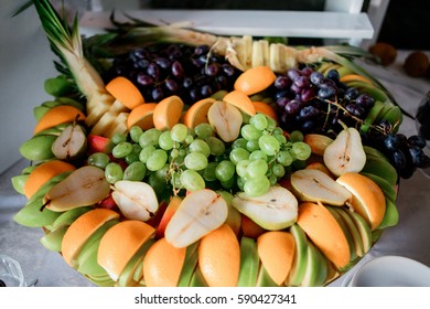Sliced oranges, pears, apples and grape served on large dish